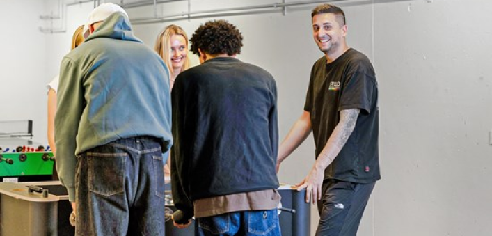 billede af fem mennesker der spiller bordfodbold